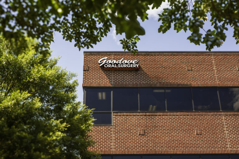 Goodove Oral Surgery brick building exterior with white signage and dark windows.